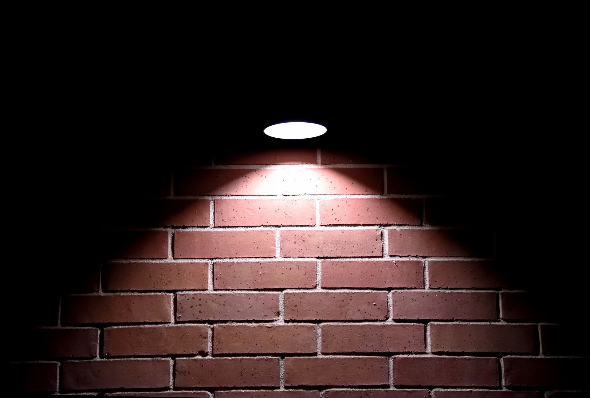 Light shining on brick wall at night